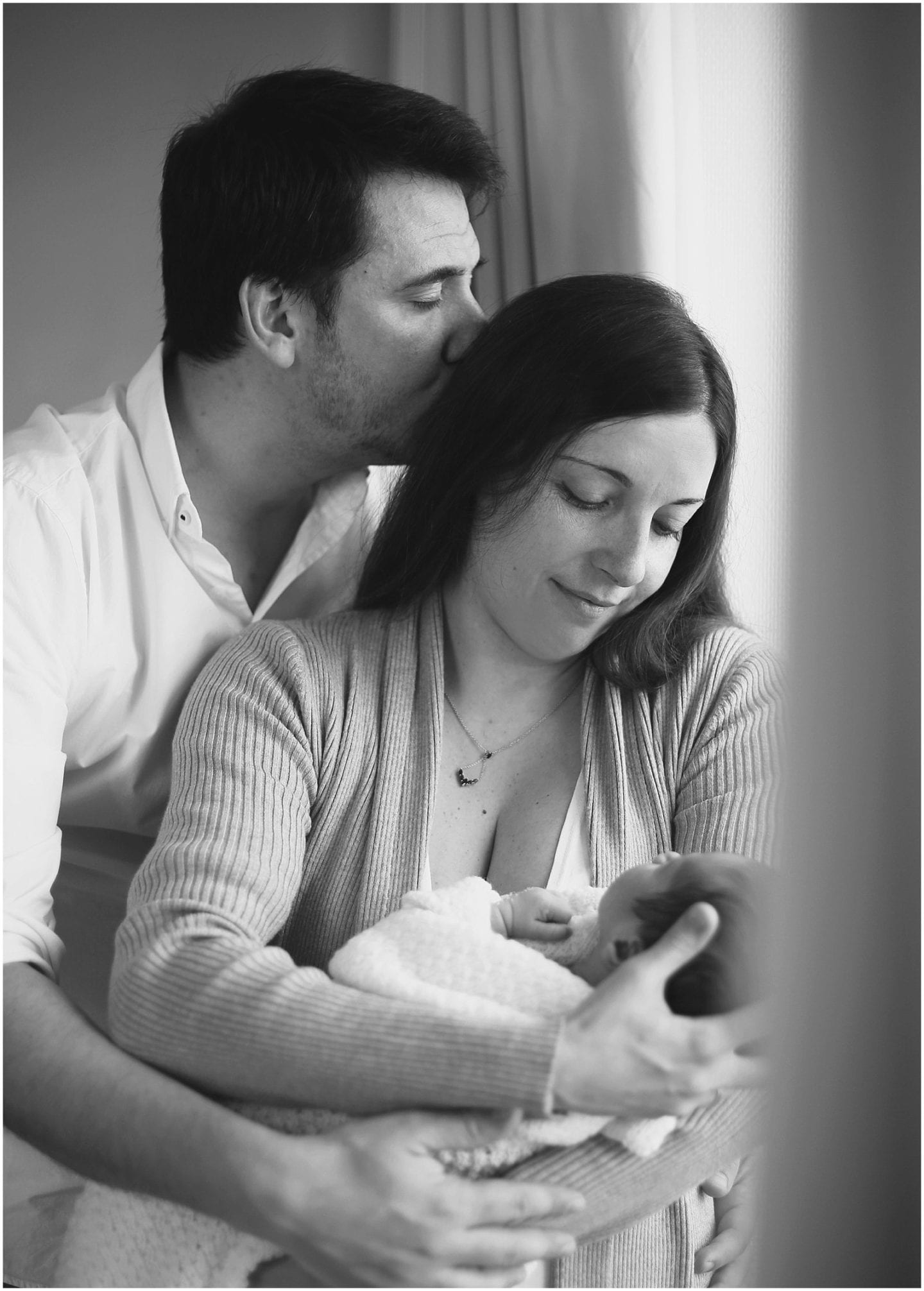 new parents holding and smiling their newborn baby photographed by Fairfield Connecticut lifestyle photographer