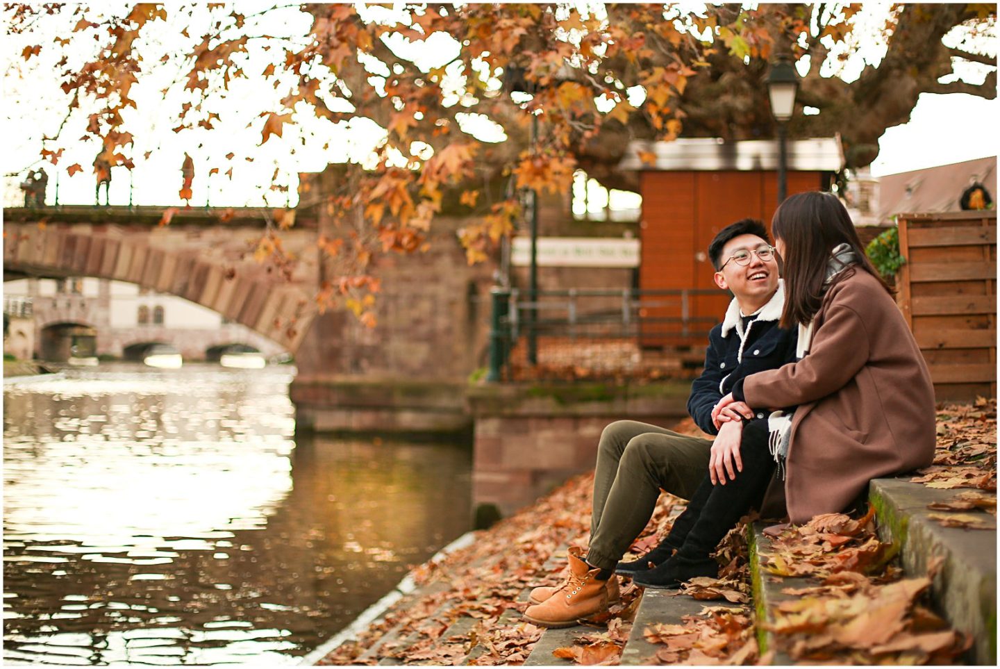 couple sitting in the autumn leaves in strasbourg 