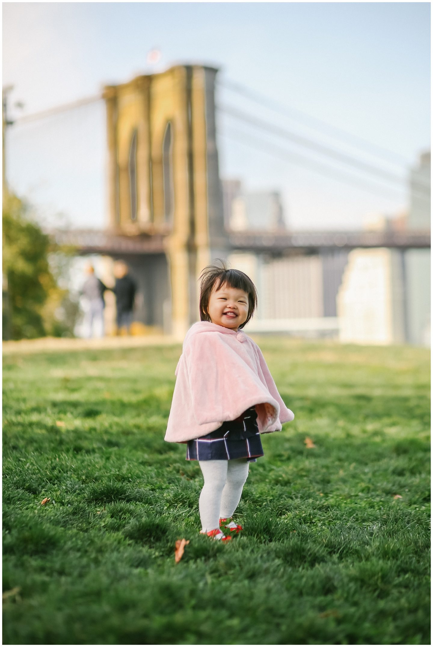 baby girl smiling for nyc family photographer in DUMBO Brooklyn bridge 