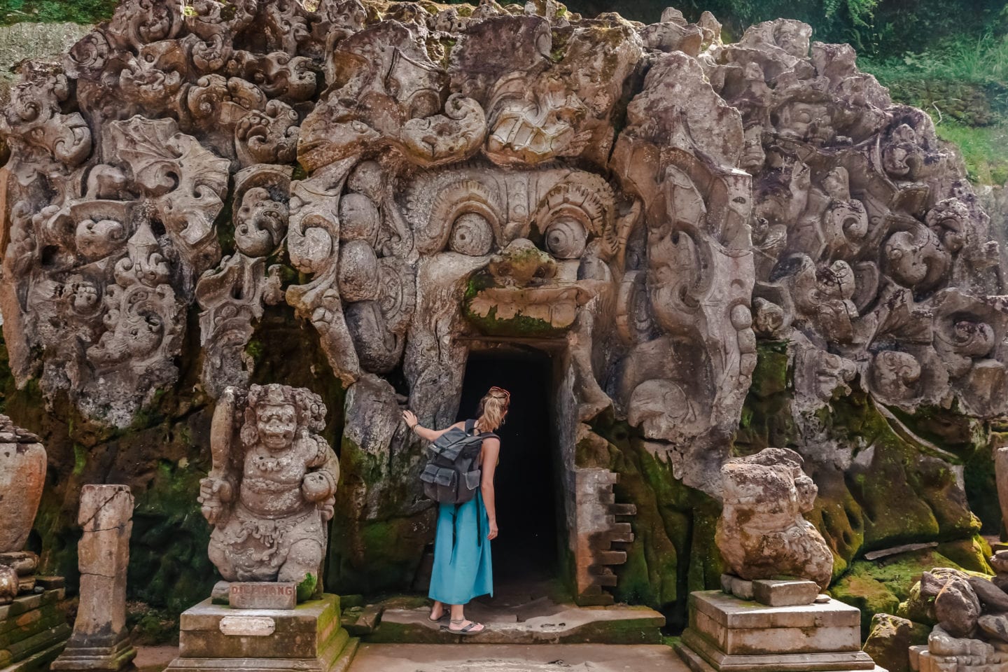 girl with backpacker looking into Goa Gajah elephant cave in Bali