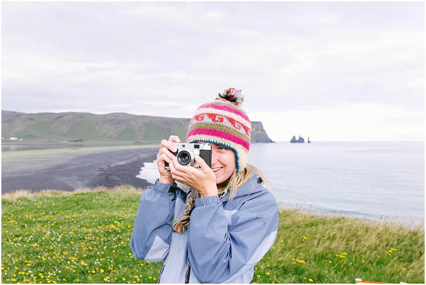 girl taking photo from a film camera while taking a technology free vacation in iceland