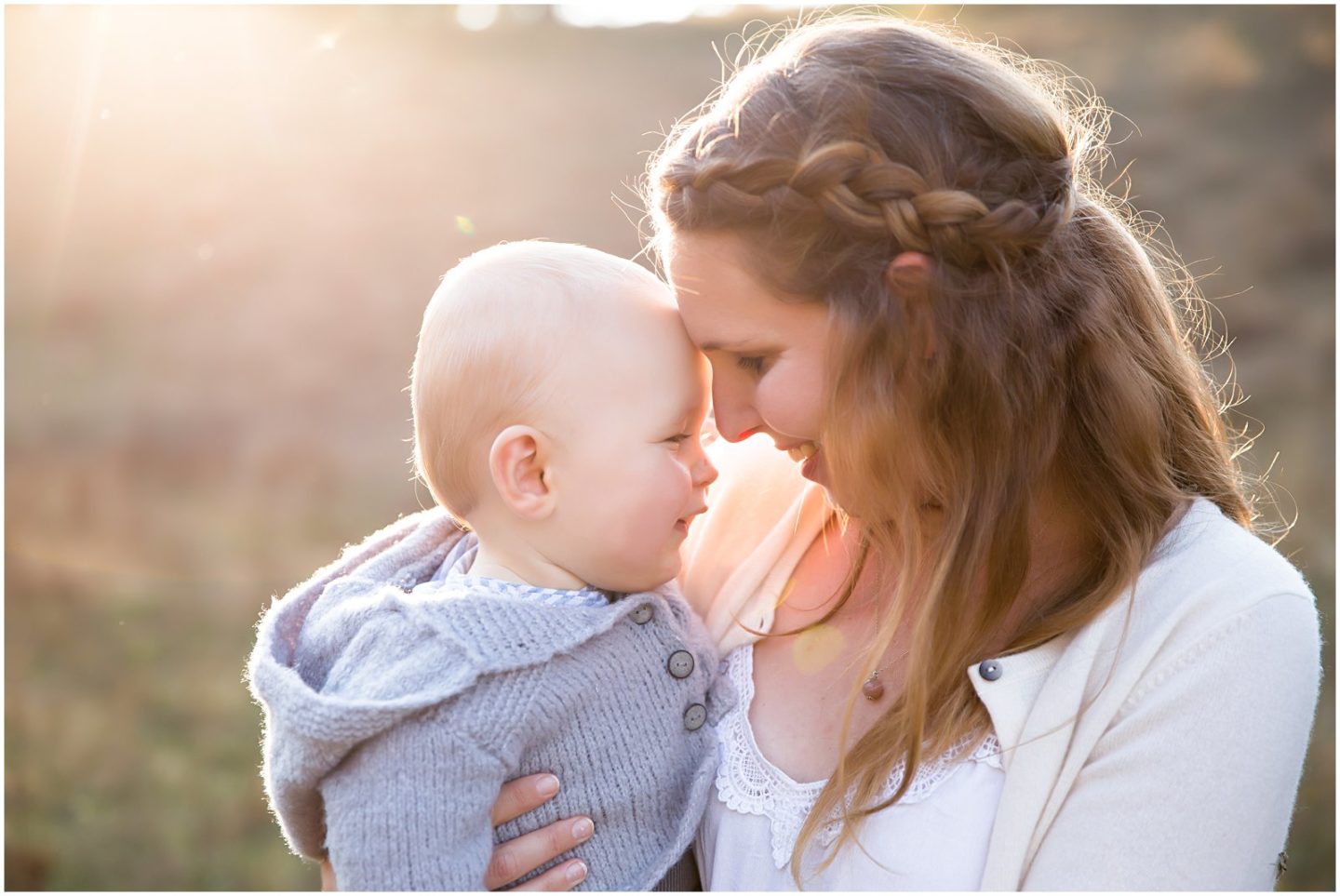 mom and baby cuddling with golden hour sun flare with helena woods