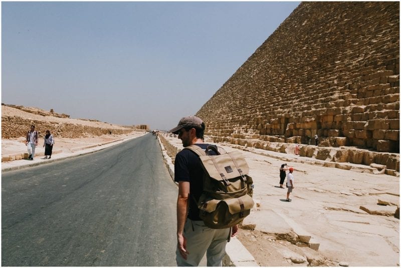 backpacker man next to pyramids of Giza in Egypt