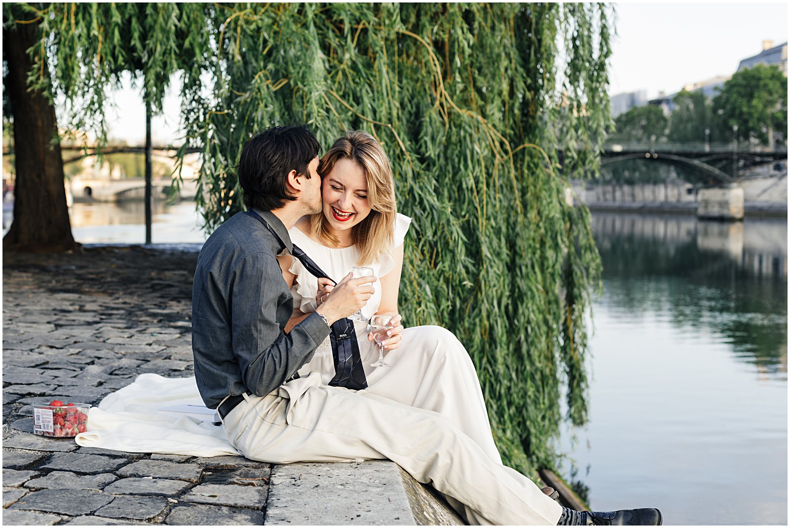married couple photographed reading along the Seine at anniversary photoshoot