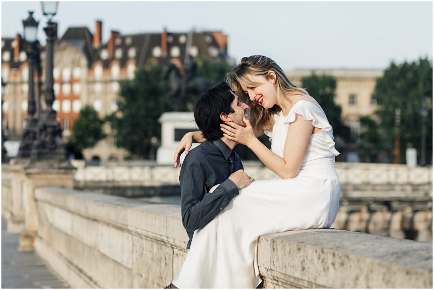 woman kissing husband along Pont Neuf bridge Paris