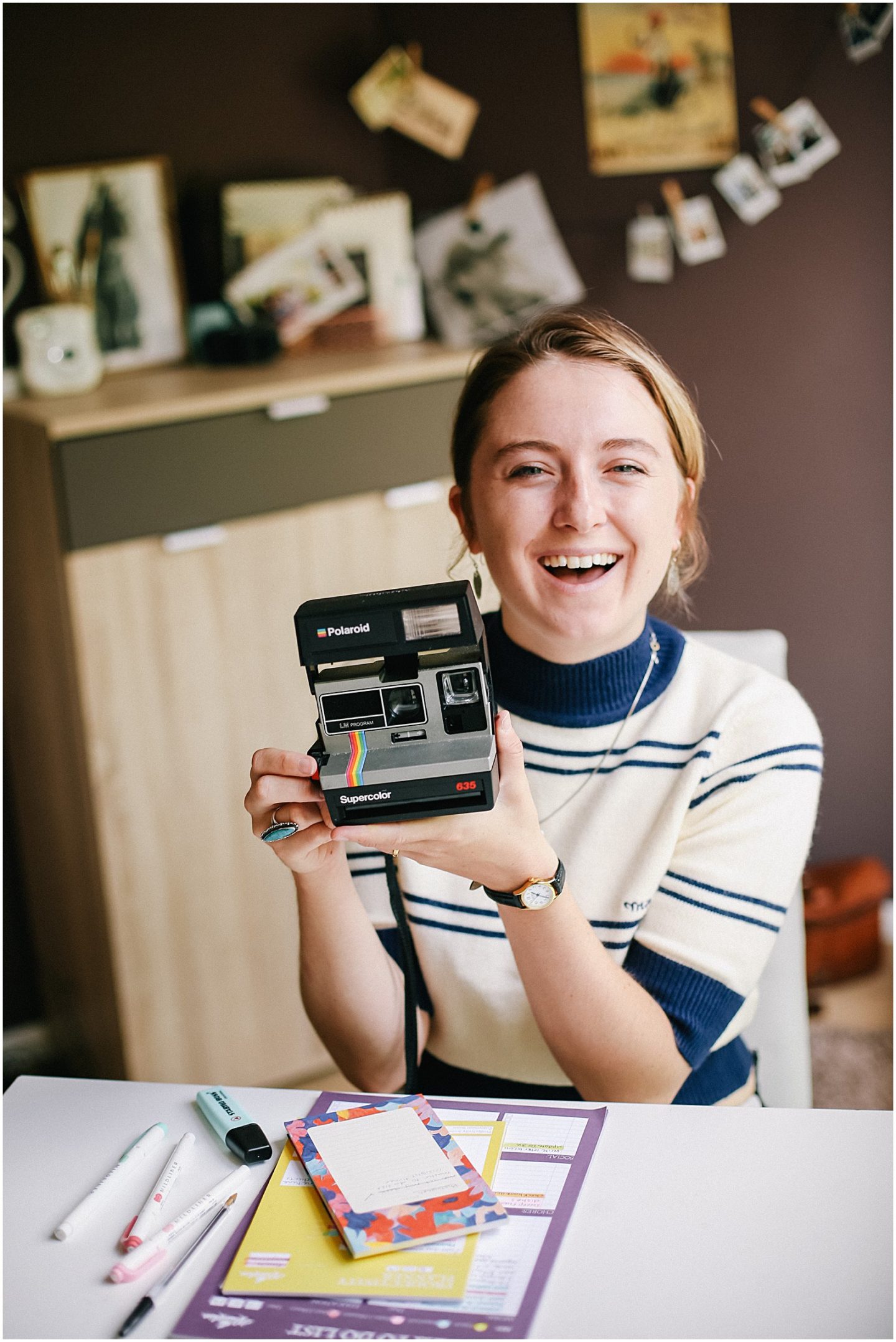 Helena Woods with vintage polaroid camera at desk 