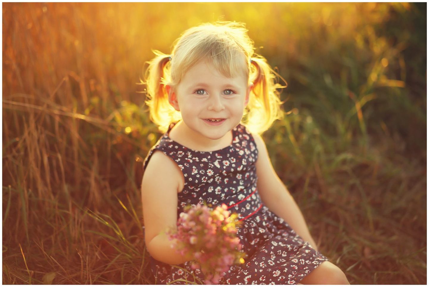 girl surrounded by golden natural light in field photographed by Helena Woods Photography