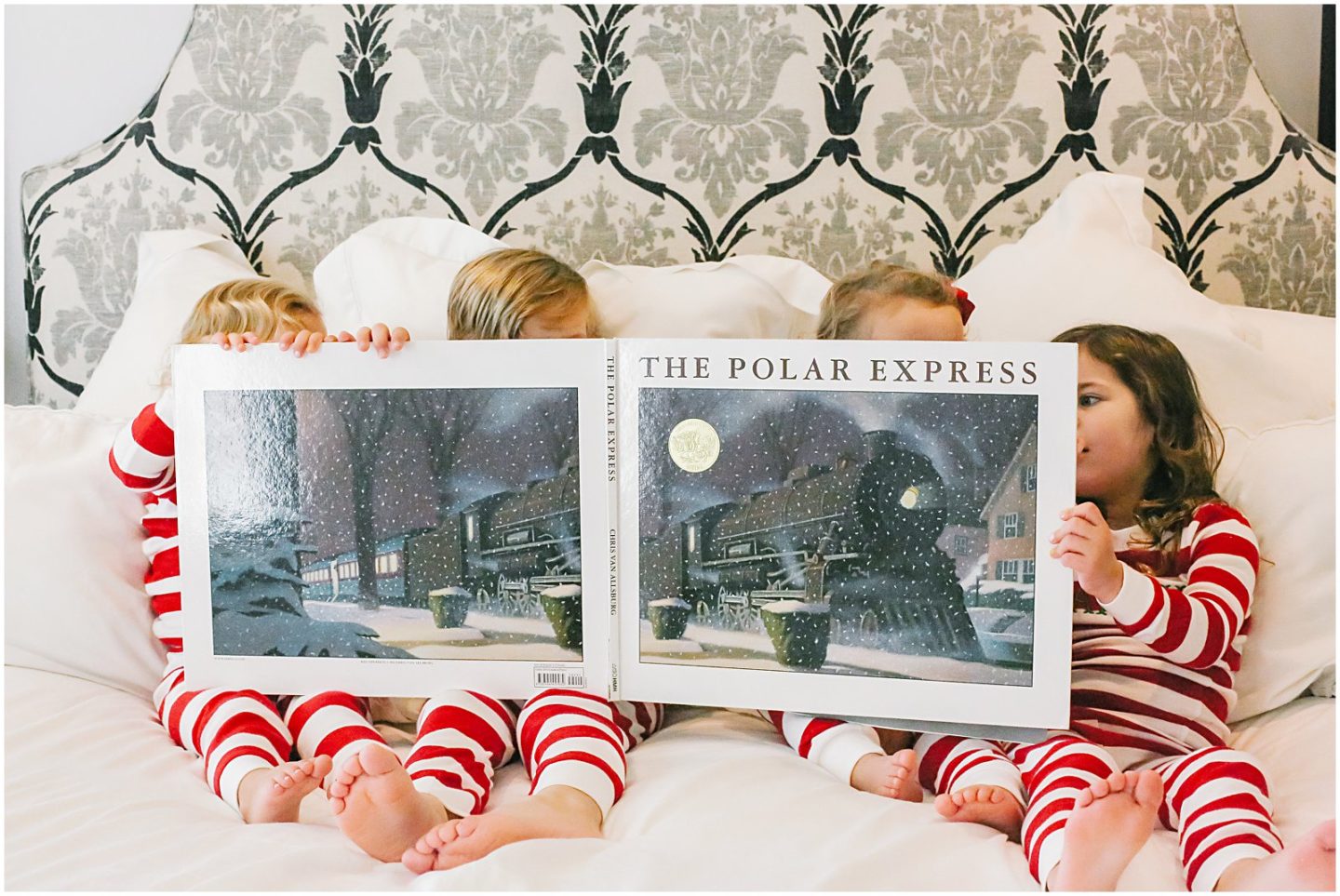 sibling children reading The Polar Express in matching christmas pajama outfits