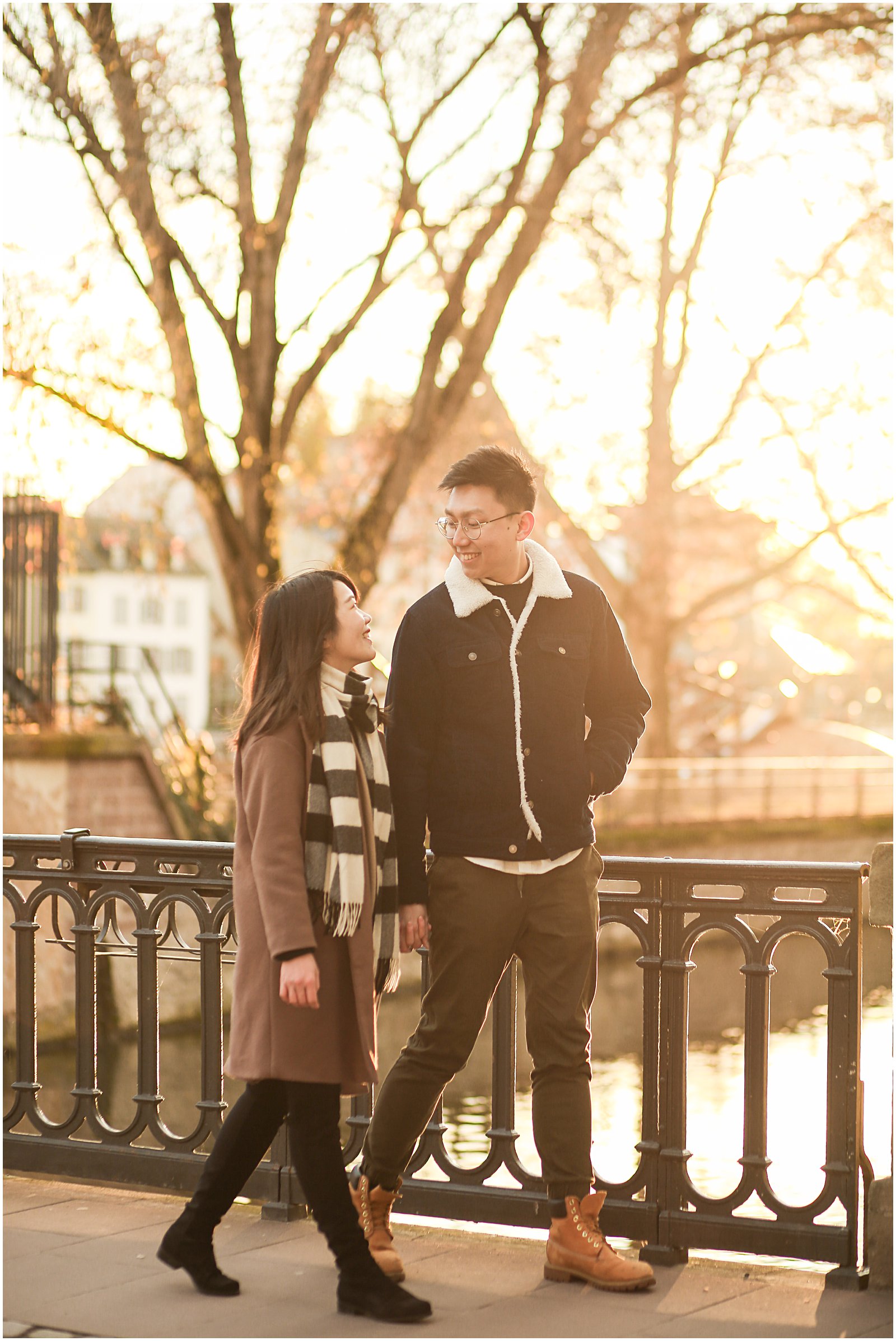 man and woman walks through Petite France at golden hour with Strasbourg engagement photographer