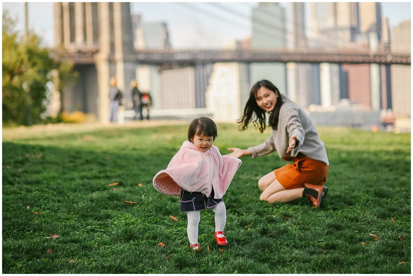baby girl and mother playing with nyc photographer in DUMBO brooklyn bridge 