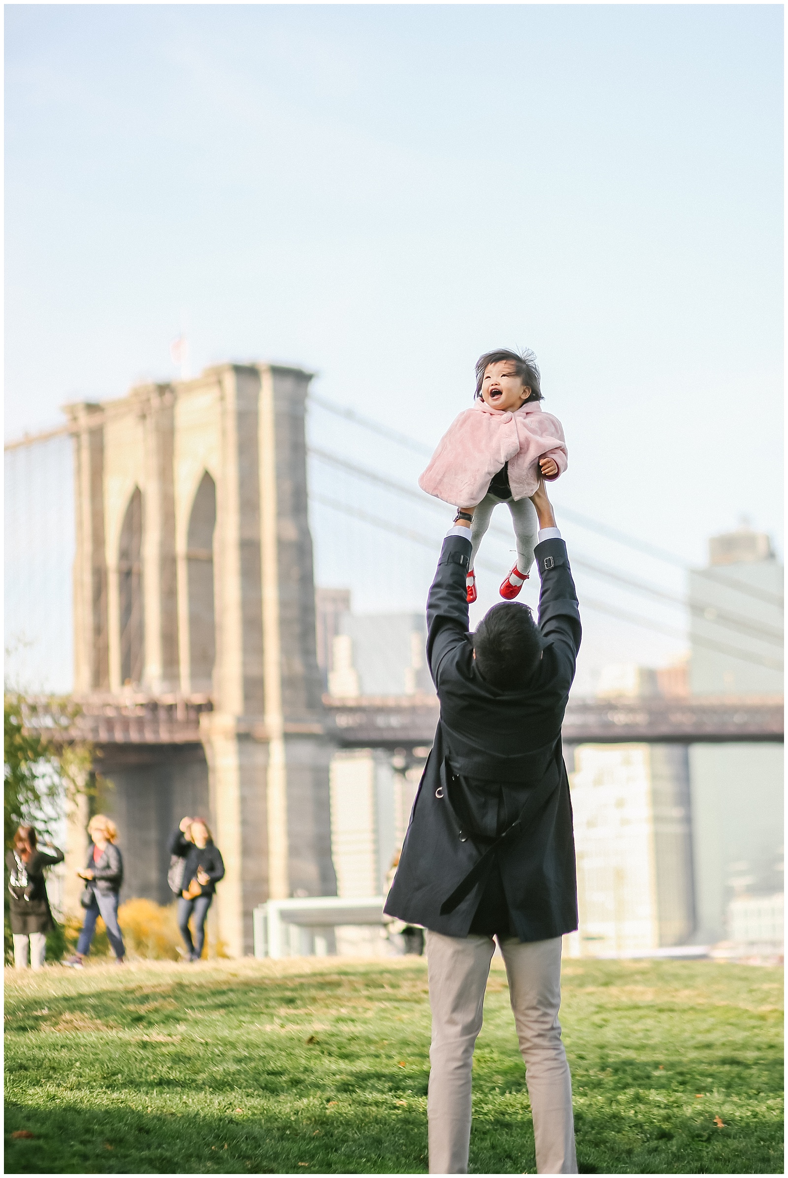dad plays with baby in Brooklyn Bridge park in dumbo with NYC Family photographer Helena