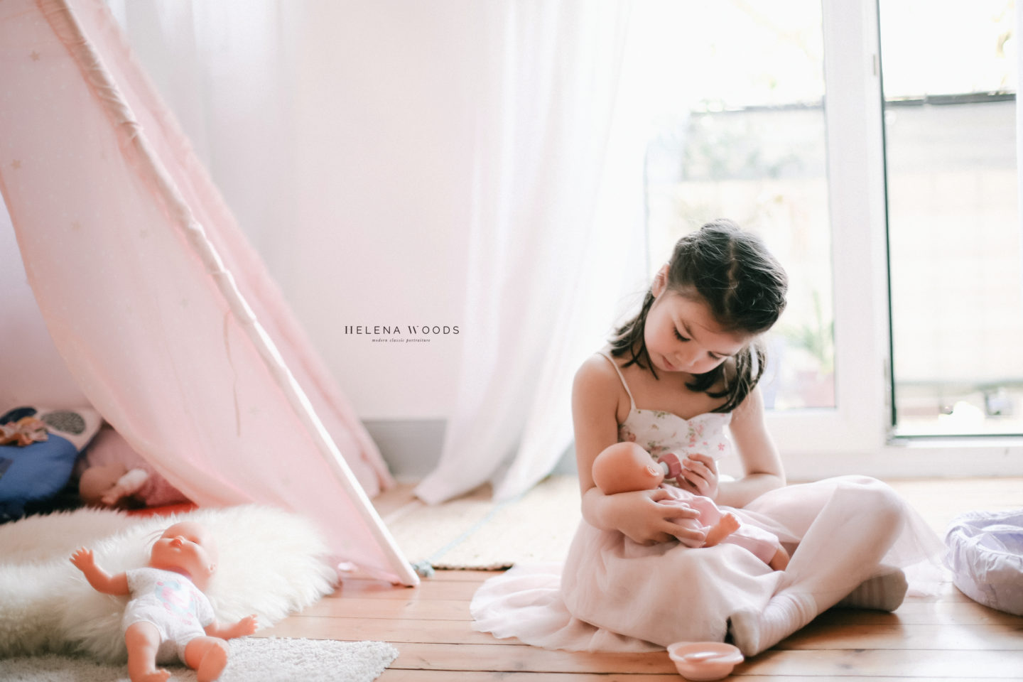 girl feeds baby doll with lifestyle family photographer Helena Woods Photography