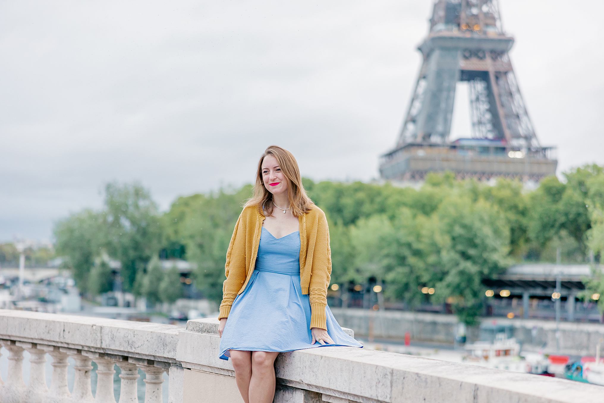 Helena Woods sitting in Paris France next to Eiffel Tower