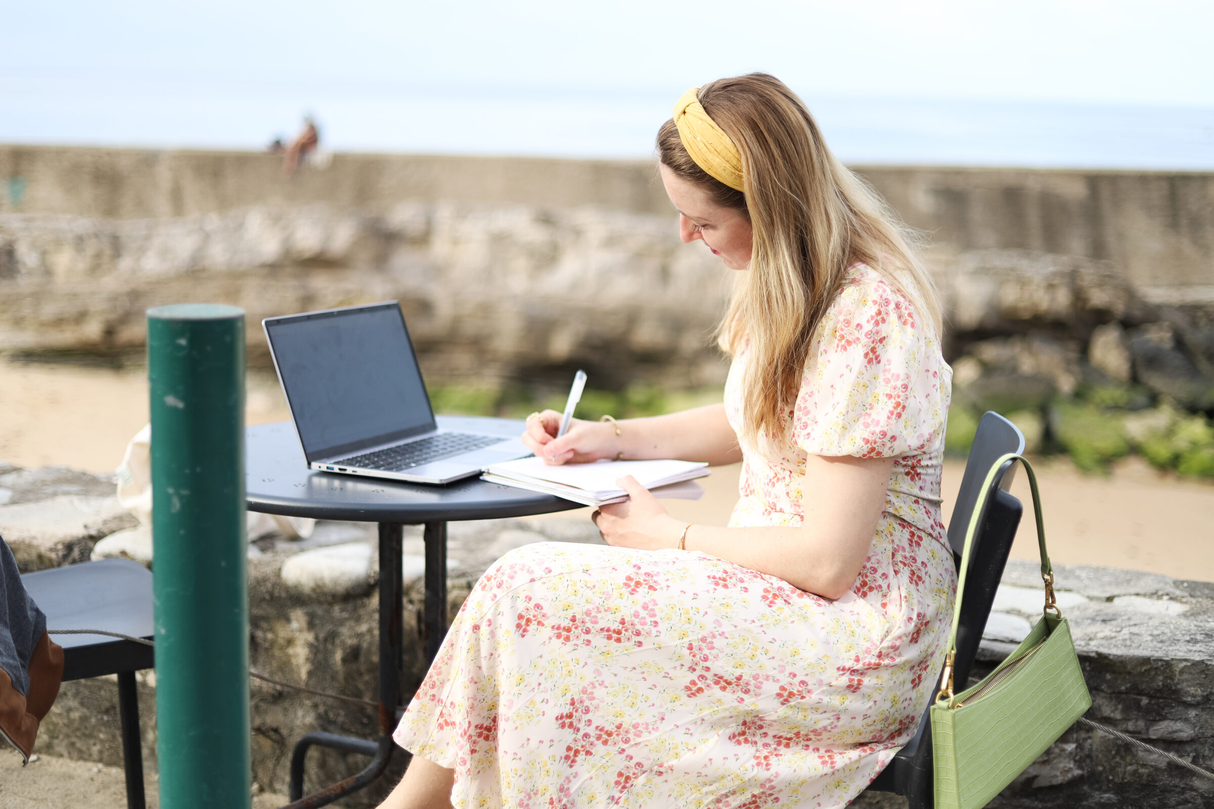 astrocartographer Helena Woods working remotely on laptop at the beach
